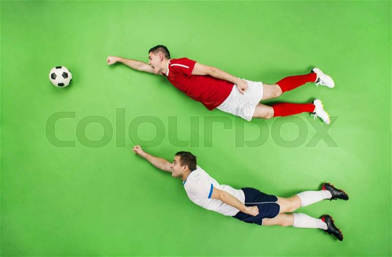 Two football players in a superman pose. Studio shot on a green backroung, stock photo
