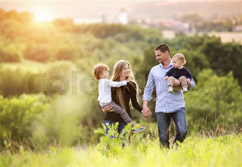 Happy young family spending time together outside in green nature, stock photo