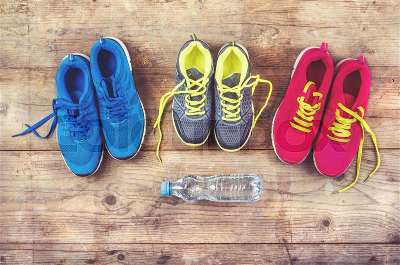 Various pairs of colorful sneakers laid on the wooden floor background, stock photo