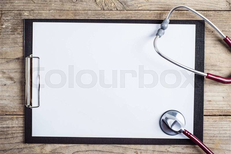 Workplace of a doctor. Stethoscope and clip board on wooden desk background, stock photo
