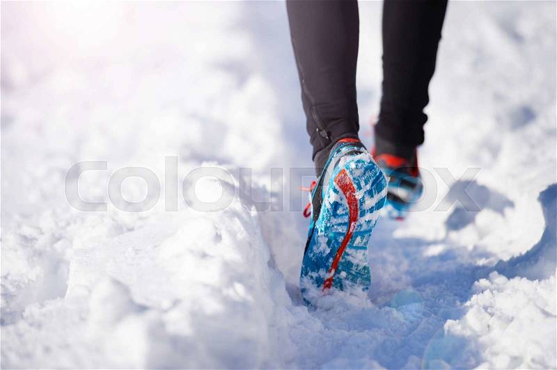 Legs of young sportsman jogging outside in a winter park, stock photo