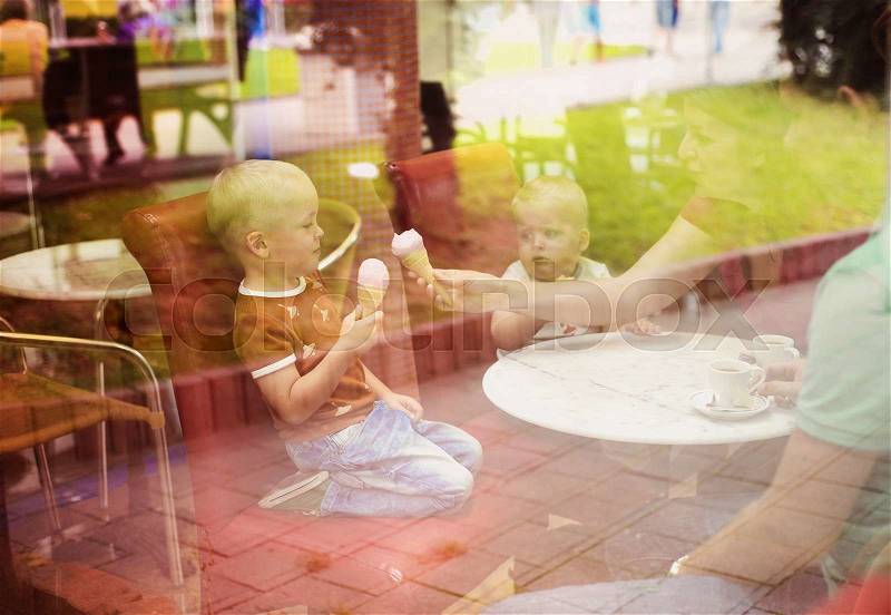 Young parents with two little boy enjoying their time in cafe, stock photo
