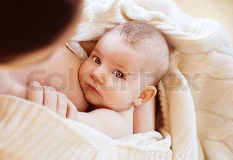 Mother breastfeeding her little baby girl in her arms, stock photo