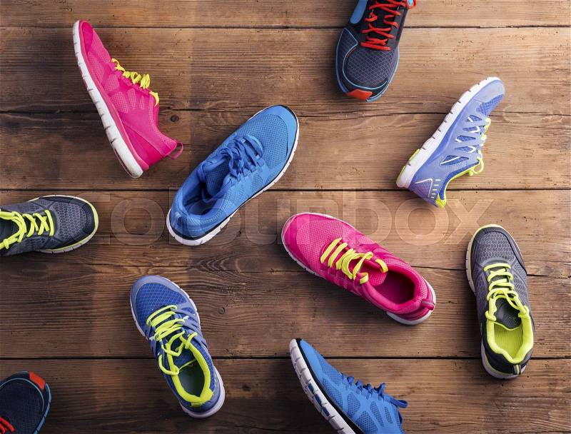 Various running shoes laid on a wooden floor background, stock photo