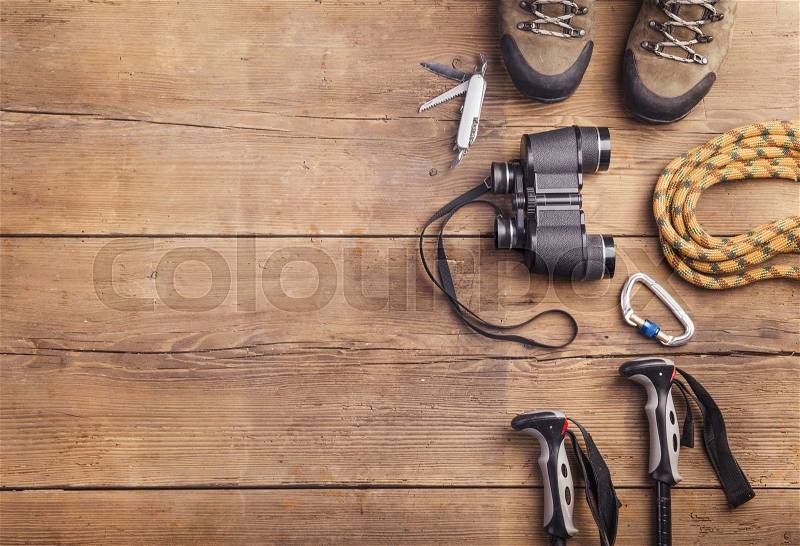 Equipment for hiking on a wooden floor background, stock photo