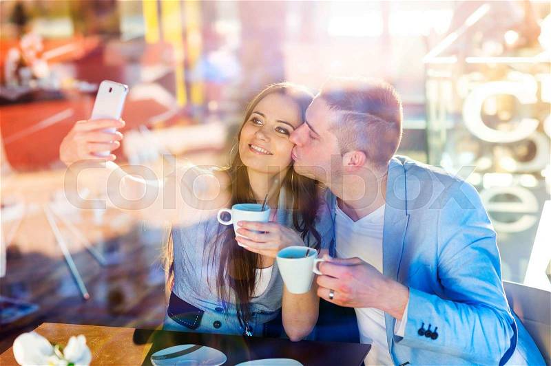 Double exposure of a beautiful young couple sitting in a cafe, stock photo