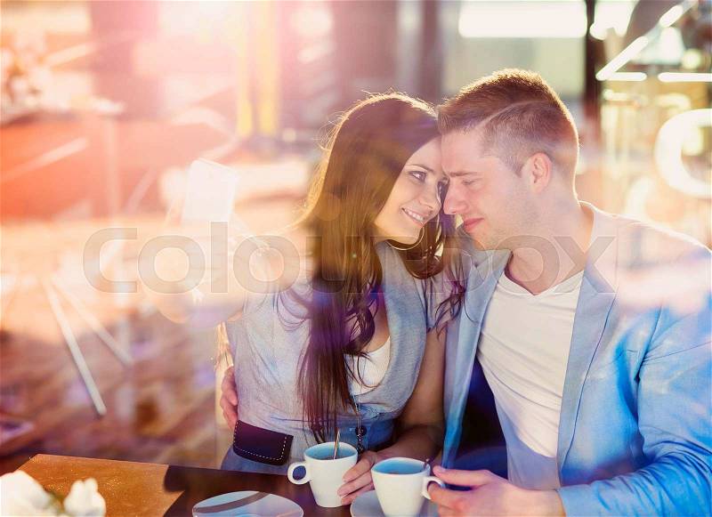 Double exposure of a beautiful young couple sitting in a cafe, stock photo