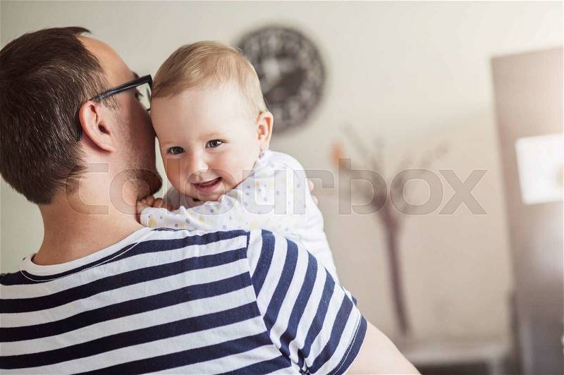 Young daddy holding his daughter in his arms, stock photo