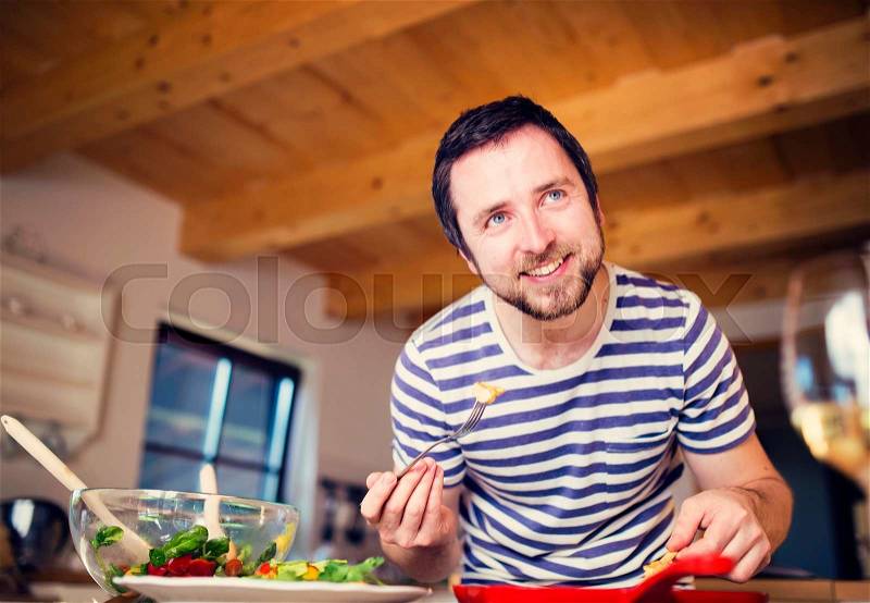 Man in the kitchen serving king prawns , stock photo