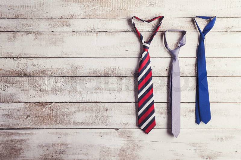 Fathers day composition of three ties hang on wooden wall background, stock photo