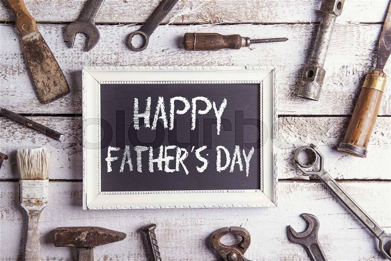 Desk of a carpenter with Happy fathers day sign. Studio shot on a wooden background, stock photo
