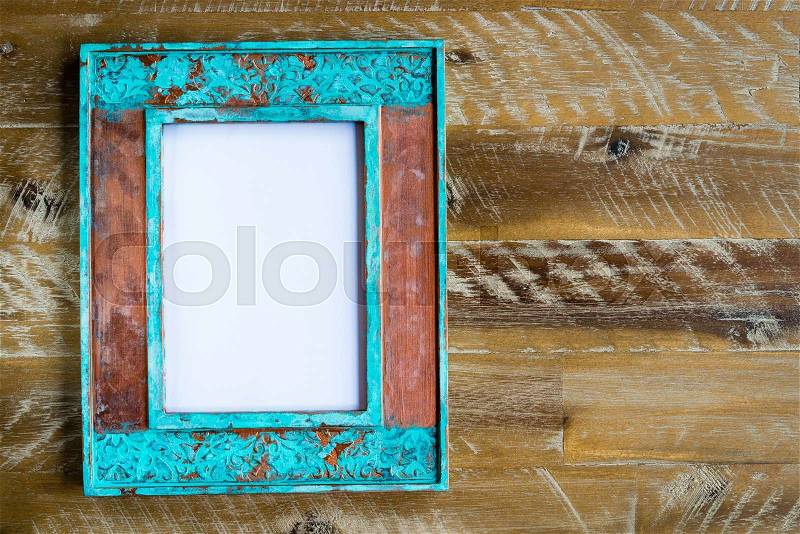 Vintage photo frame over wood background with empty white canvas, copy space available, stock photo