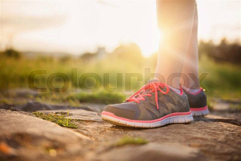 Feet of a young runner training outside in spring nature, stock photo