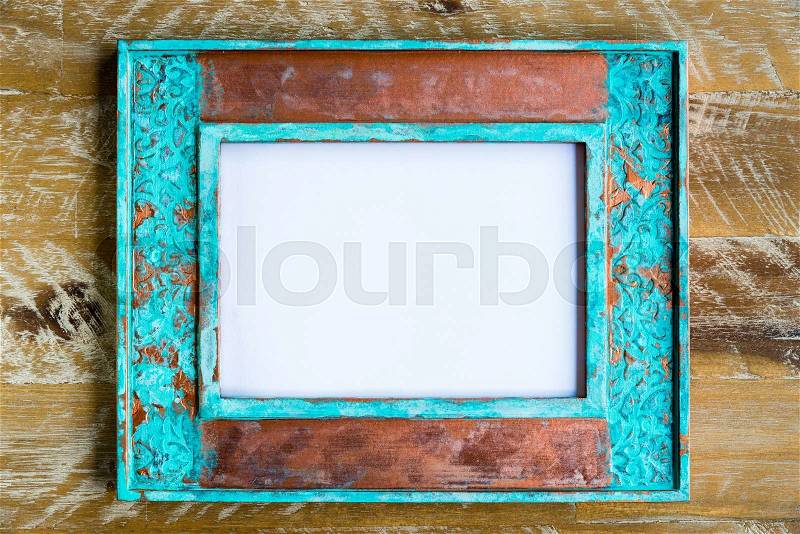 Vintage photo frame over wood background with empty white canvas, copy space available, stock photo