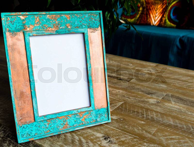 Vintage photo frame on wooden table background with empty white canvas, copy space available, stock photo