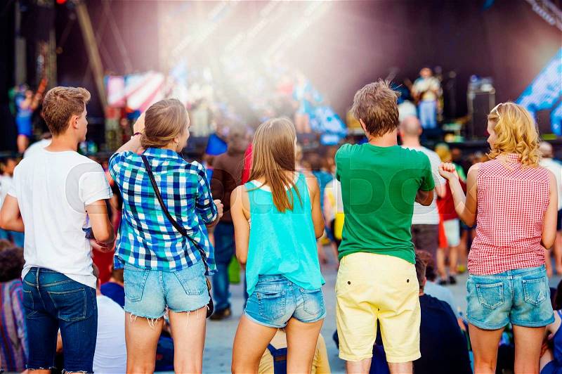 Group of beautiful teens at concert at summer festival, stock photo
