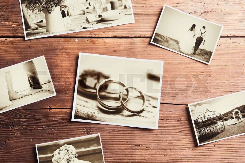 Wedding photos laid on a table. Studio shot on wooden background, stock photo
