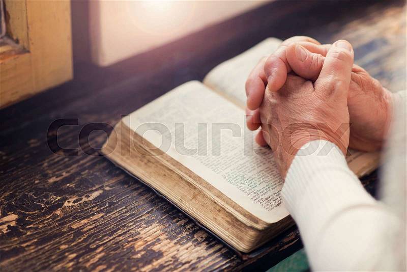 Unrecognizable woman holding a bible in her hands and praying, stock photo