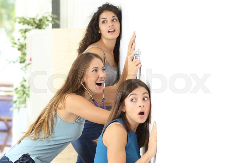 Three gossip girls listening through the neighbour wall at home, stock photo