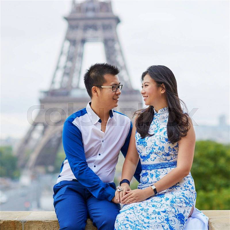 Young romantic Asian couple having a date near the Eiffel Tower, Paris, France, stock photo