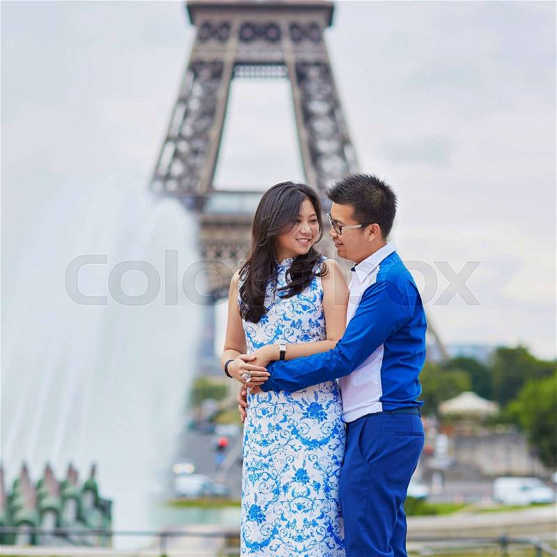 Young romantic Asian couple having a date near the Eiffel Tower, Paris, France, stock photo