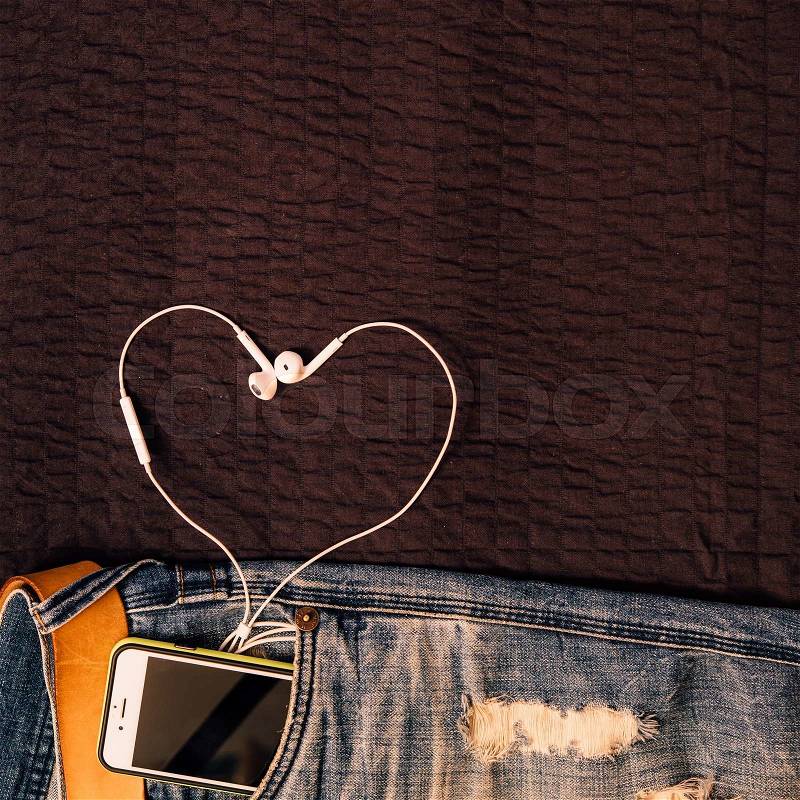 Texture background of jeans , belt detail with mobilephone and earphone as heart shape, stock photo