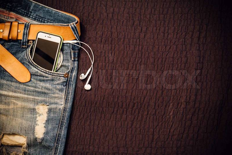 Texture background of jeans , belt detail with mobilephone and earphone in pocket and free copy space, stock photo