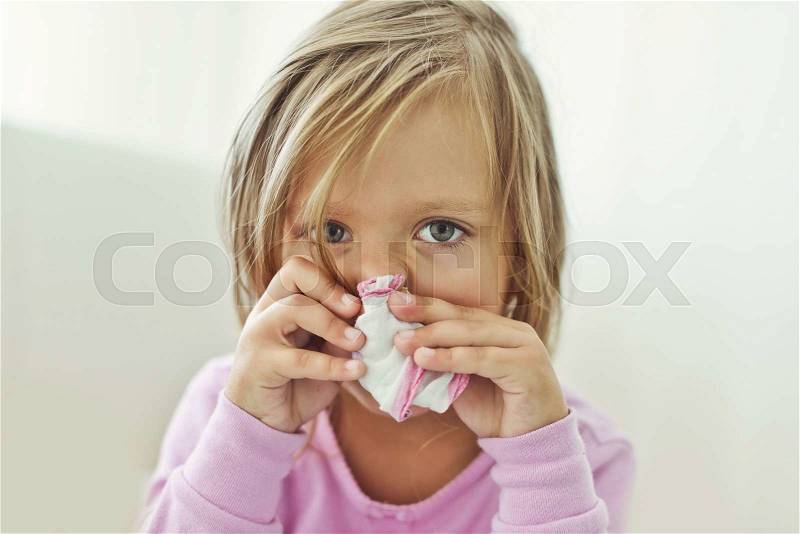 Sick toddler girl with handkerchief at the home, stock photo