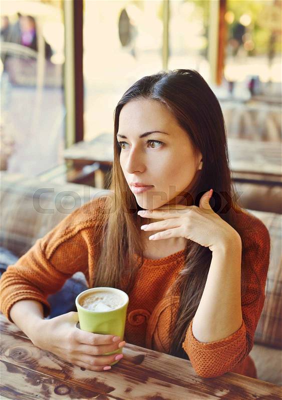 Woman with morning coffee in cafe in fall time, stock photo