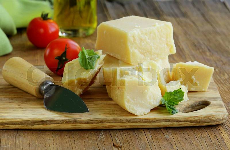 Hard natural parmesan cheese on a wooden board, stock photo