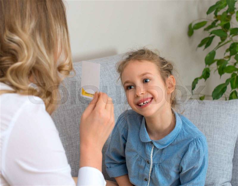 Mother and daughter playing board game at home, stock photo