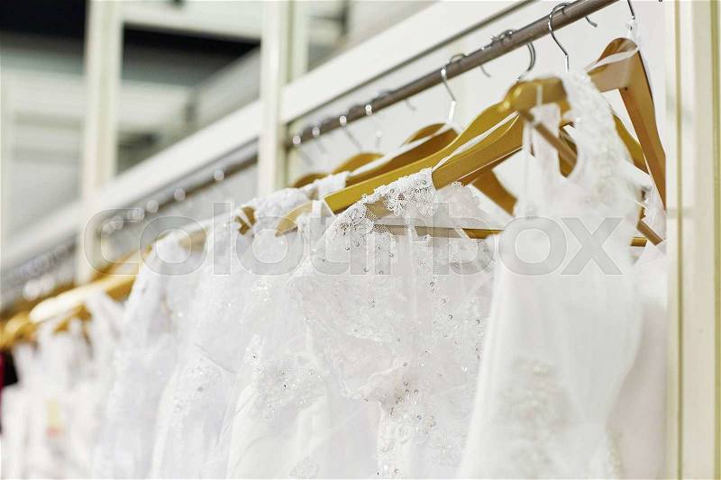 Collection of elegant wedding dresses in the shop, stock photo