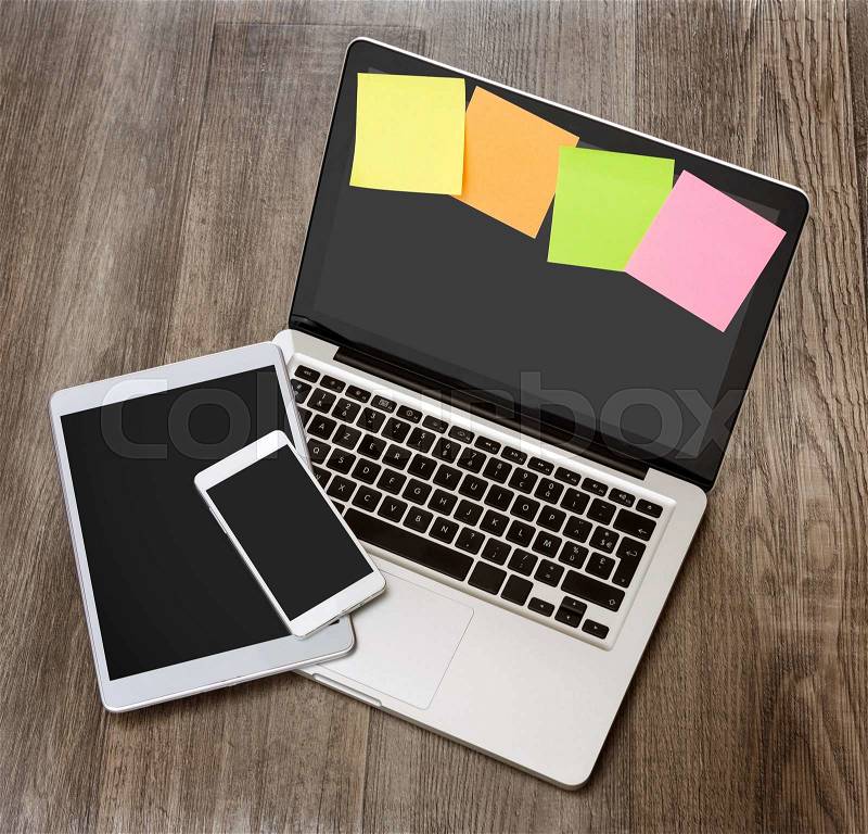 View of a Laptop in high definition with tablet and mobile phone on a wood background, stock photo