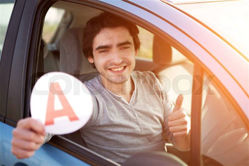 View of a Young man happy to get his driving license, stock photo
