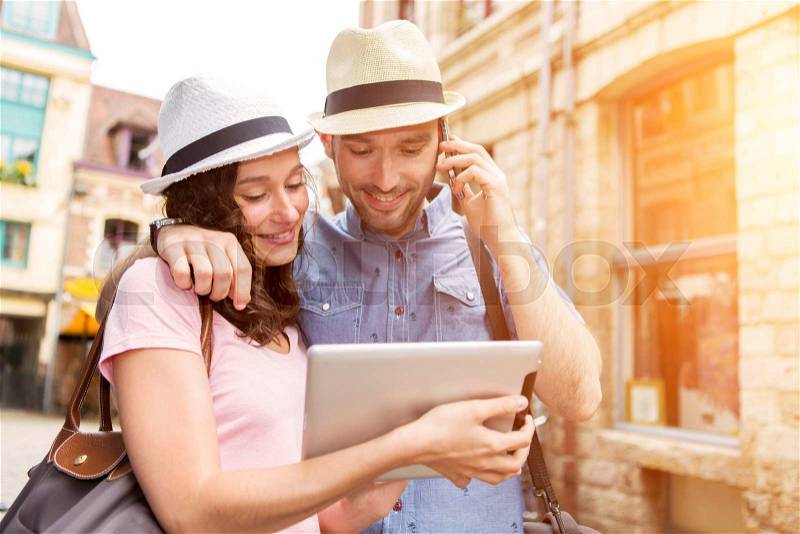 View of a Couple of young attractive tourists discovering city on holidays, stock photo