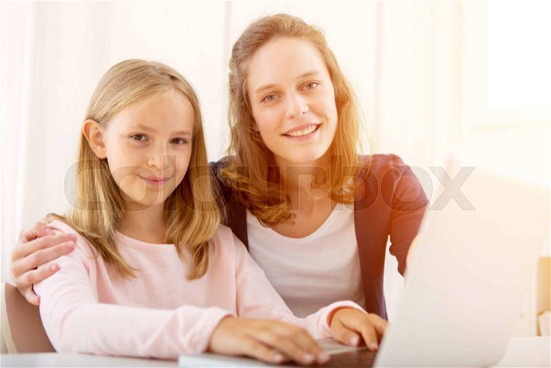 View of a Woman helping out her little sister for homework, stock photo
