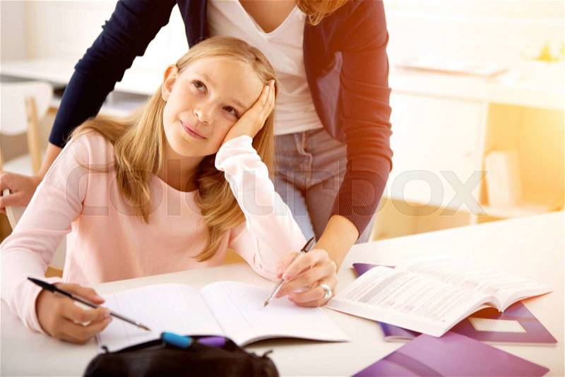 View of a Woman helping out her little sister for homework, stock photo