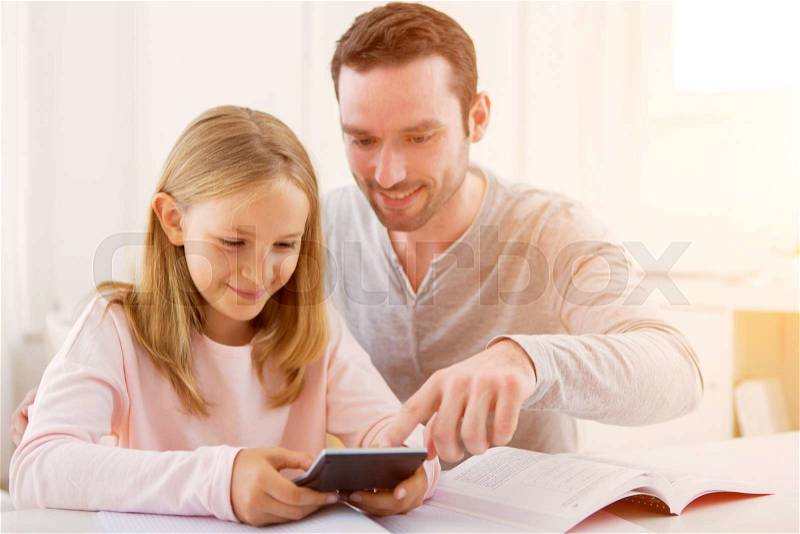 VIew ofa Father helping out her daughter for homework, stock photo