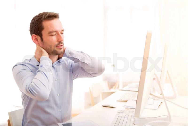 View of a Young attractive man got a headache at the office, stock photo
