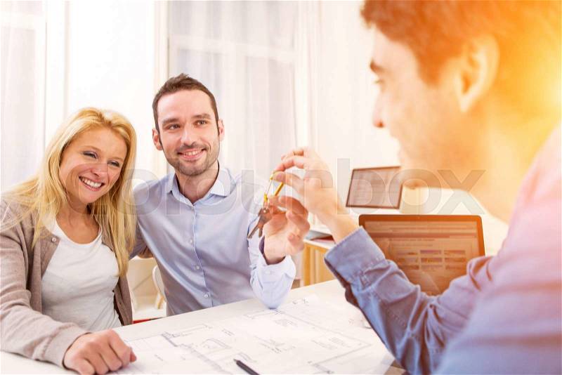 View of a young serious couple meeting a real estate agent, stock photo