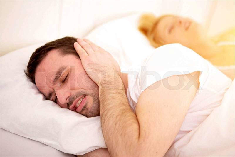 View of a Young man can\'t sleep because of girlfriend\'s snoring, stock photo