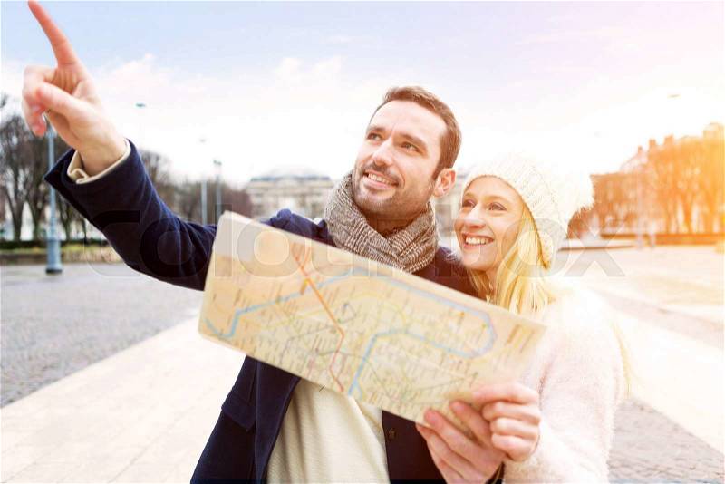 View of a Couple of young attractive tourists watching map , stock photo