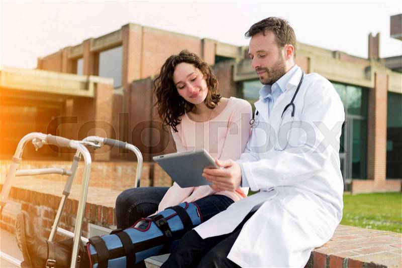 View of a Doctor showing reeducation\'s tips on tablet, stock photo