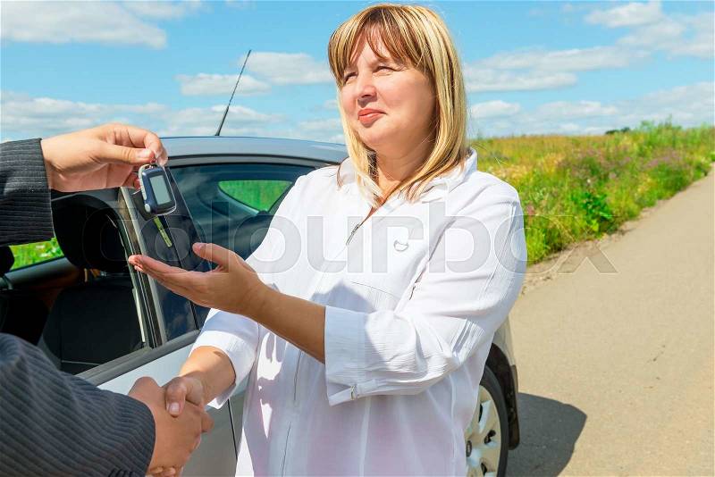 Female 50 years, bought a new car and get key, stock photo