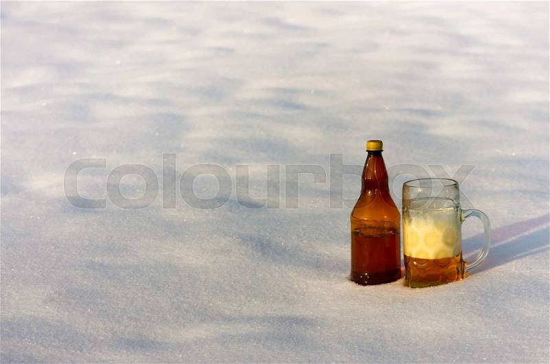 A mug of beer standing in the snow in the winter, stock photo