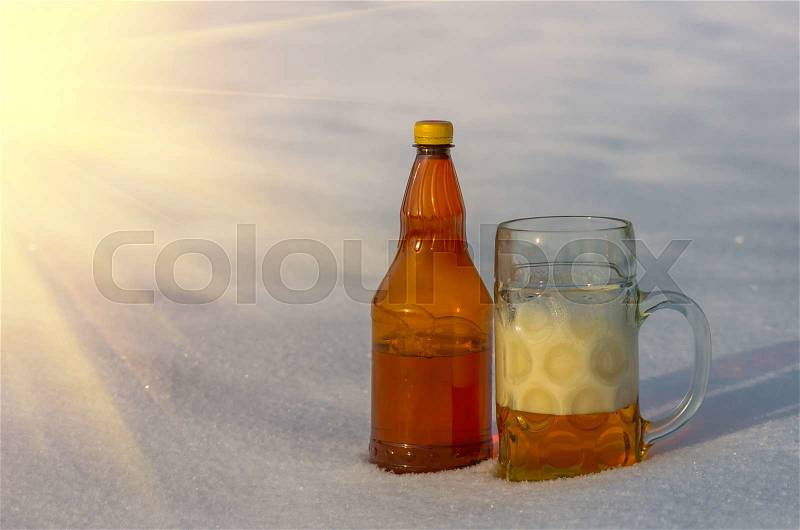 A mug of beer standing in the snow in the winter, stock photo