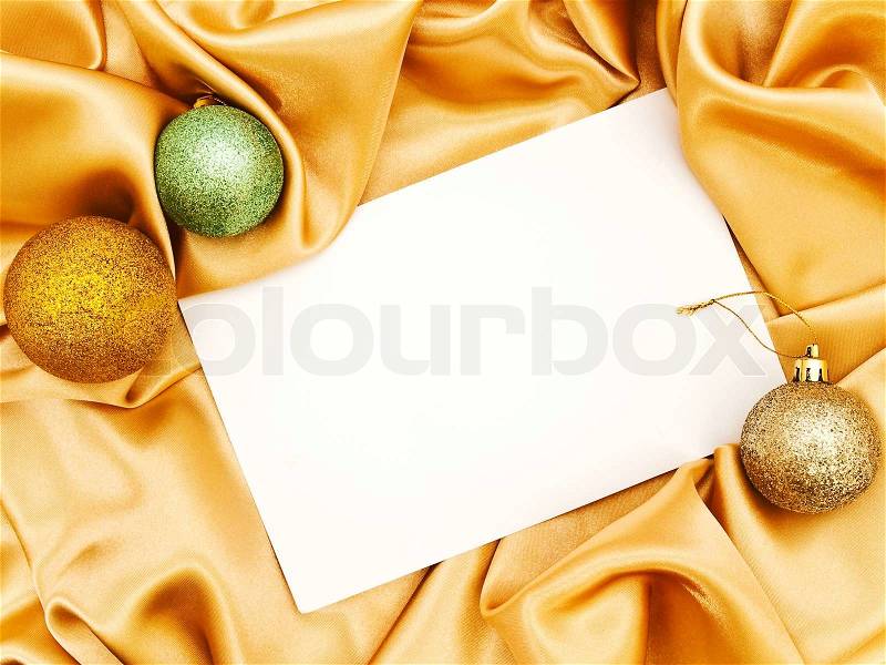 Blank Christmas invitation with decoration balls over golden cloth, stock photo