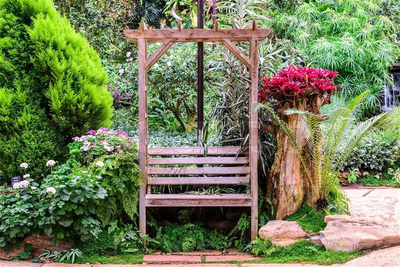 Wooden bench among the flower garden, stock photo