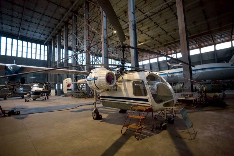 Old soviet helicopter on maintenance in hangar, stock photo