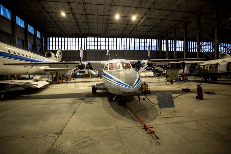 Toned photo of hangar with civil airplanes at night, stock photo